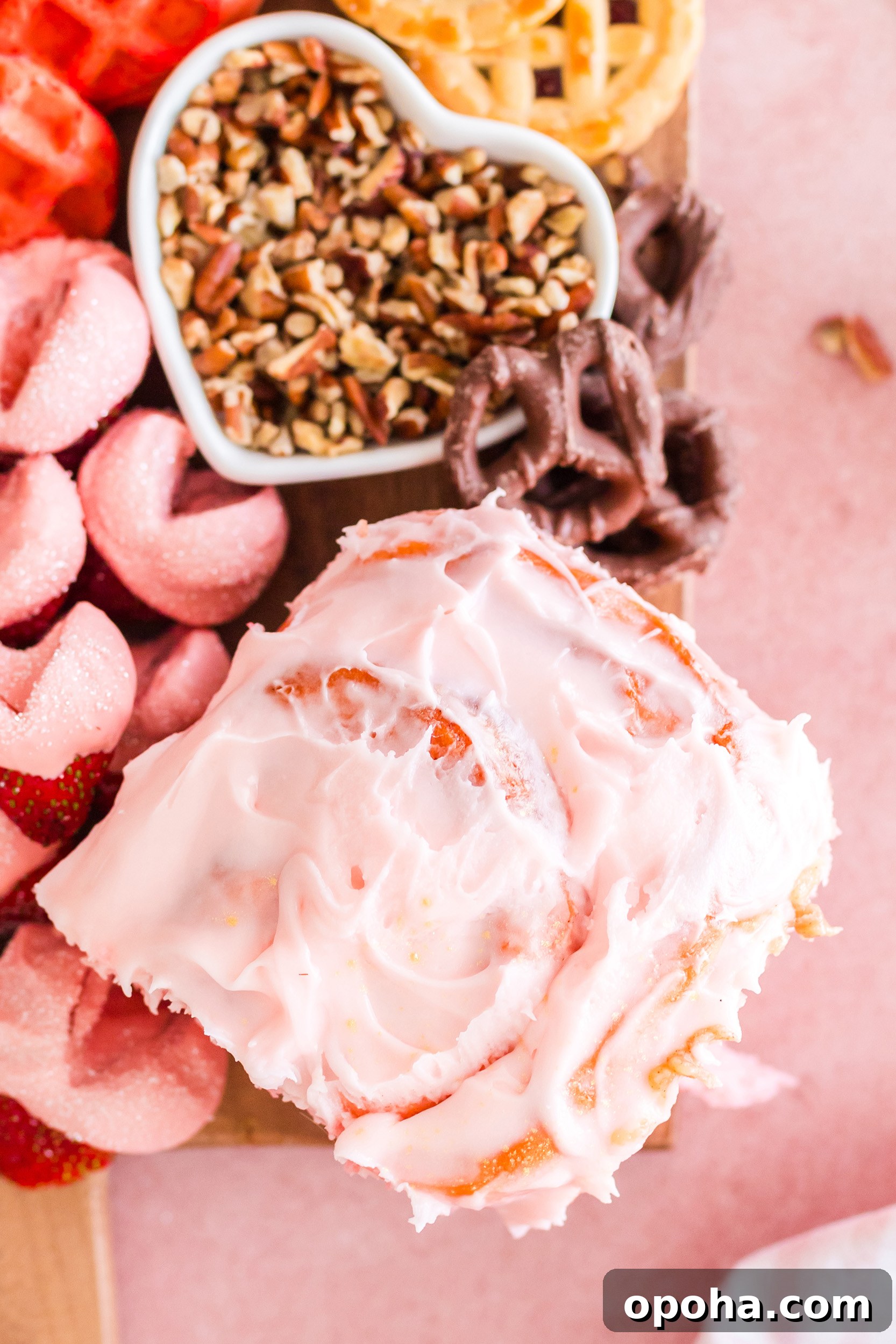 strawberry cinnamon roll on a board with other sweets and breakfast treats