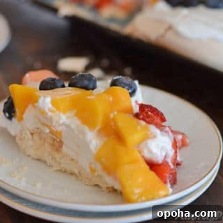 Easter Pavlova Recipe with Fresh Fruit Topping 13 A piece of cake on a plate with fruits
