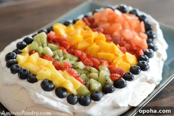 Easter Pavlova Recipe with Fresh Fruit Topping 11 A plate of food on a table, with Pavlova and Fruit