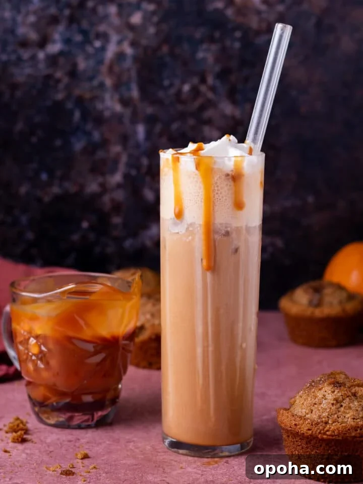 tall glass with iced salted caramel latte, small pitcher of salted caramel syrup and pumpkin muffins