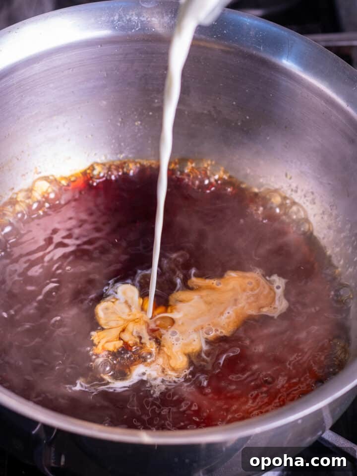 pouring heavy cream into the burnt sugar mixture