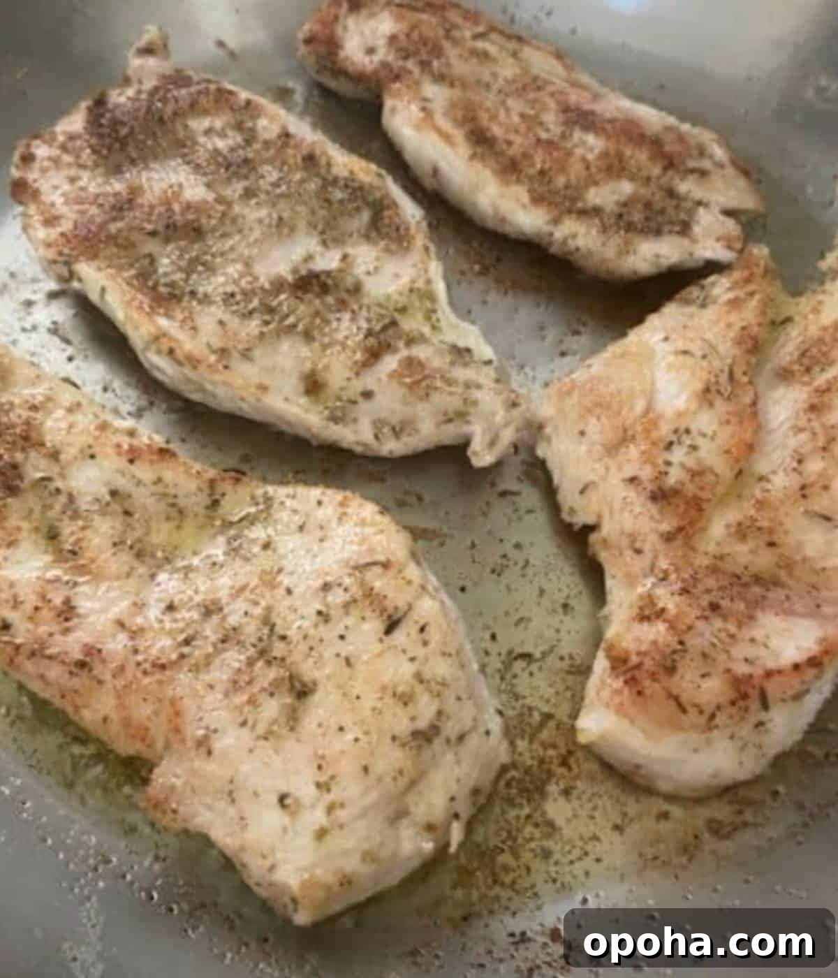 Perfectly Sautéed Chicken Breasts with Garlic and Herbs 7 Chicken sautéing in skillet on stovetop.