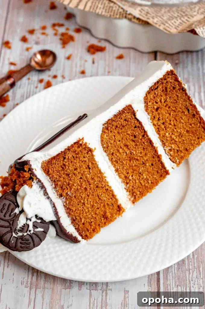 Gluten-Free Pumpkin Bars with Dairy-Free Option - Moist Fall Treat 8 A tall pumpkin layer cake frosted with white cream cheese buttercream and topped with chocolate ganache, chocolate cookies, and white frosting swirls.