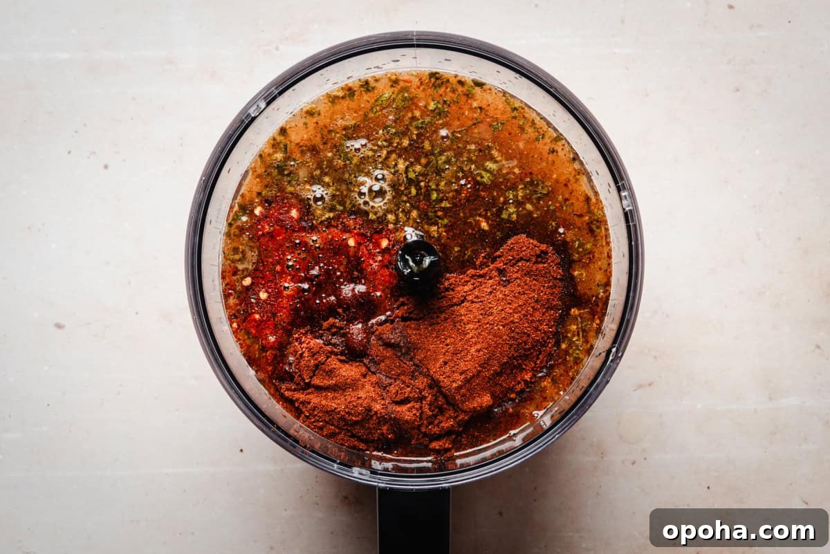 Authentic New Mexican Carne Adovada Recipe 9 A food processor contains a blend of spices and liquids, ready to be mixed.