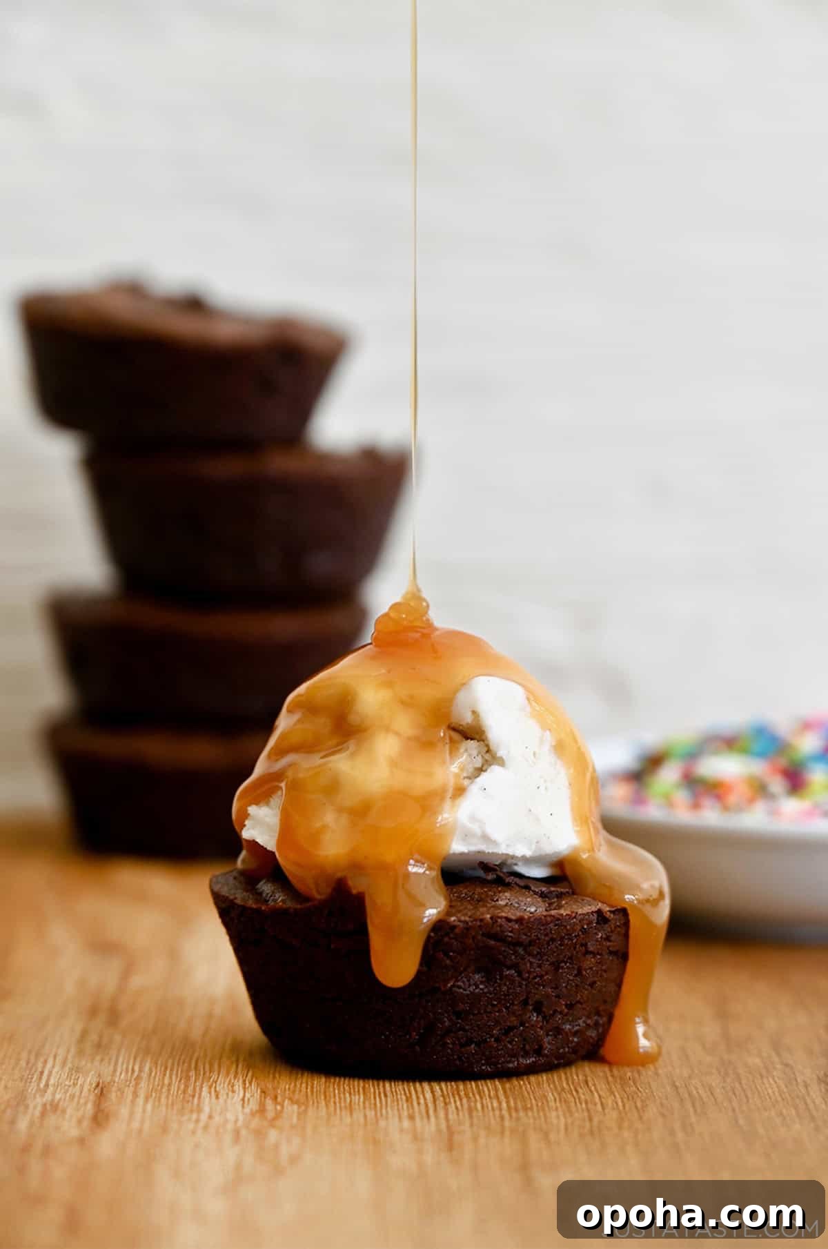 Fudgy From-Scratch Brownie Cupcakes Recipe 2 A fudgy brownie cupcake topped with vanilla bean ice cream and a thick drizzle of caramel sauce.