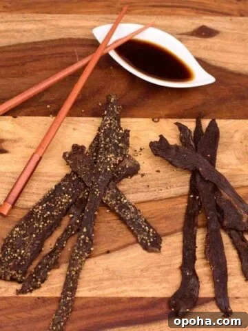 Deer jerky on cutting board with marinade in white dish
