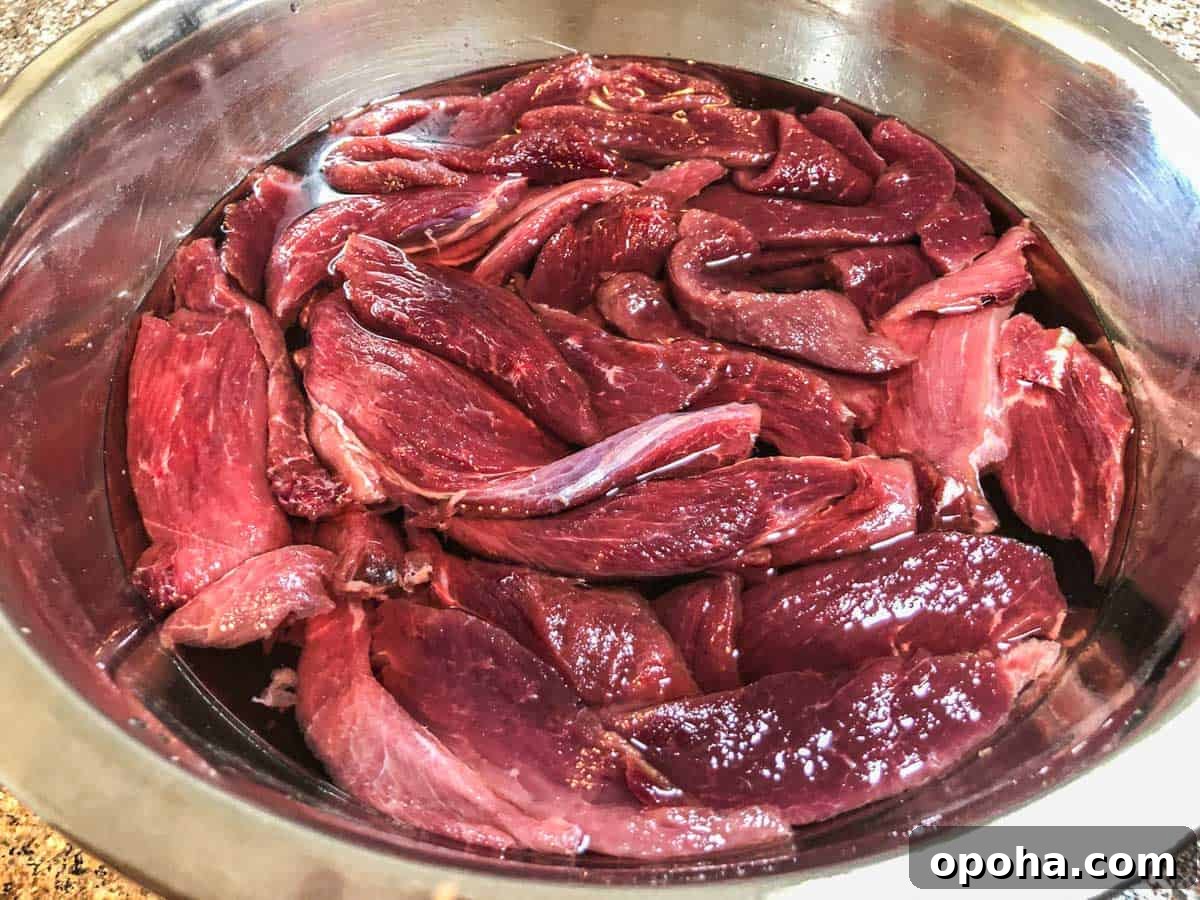 Sesame-Glazed Venison Jerky Recipe: Savory Sweet Game Meat Snack 3 Venison soaking in salt water bowl