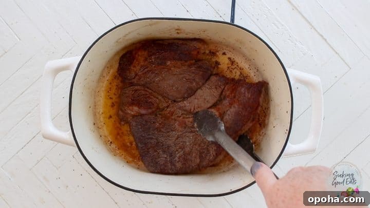 Searing the beef in an oven proof stock pot.