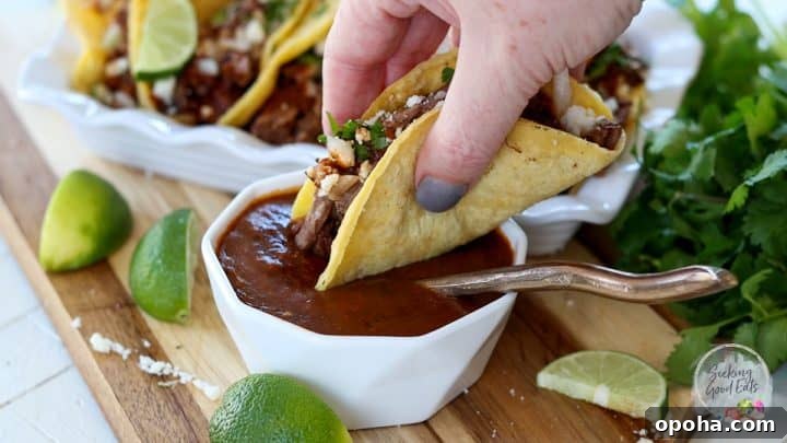 Dipping a birria taco in the consomme dipping sauce.