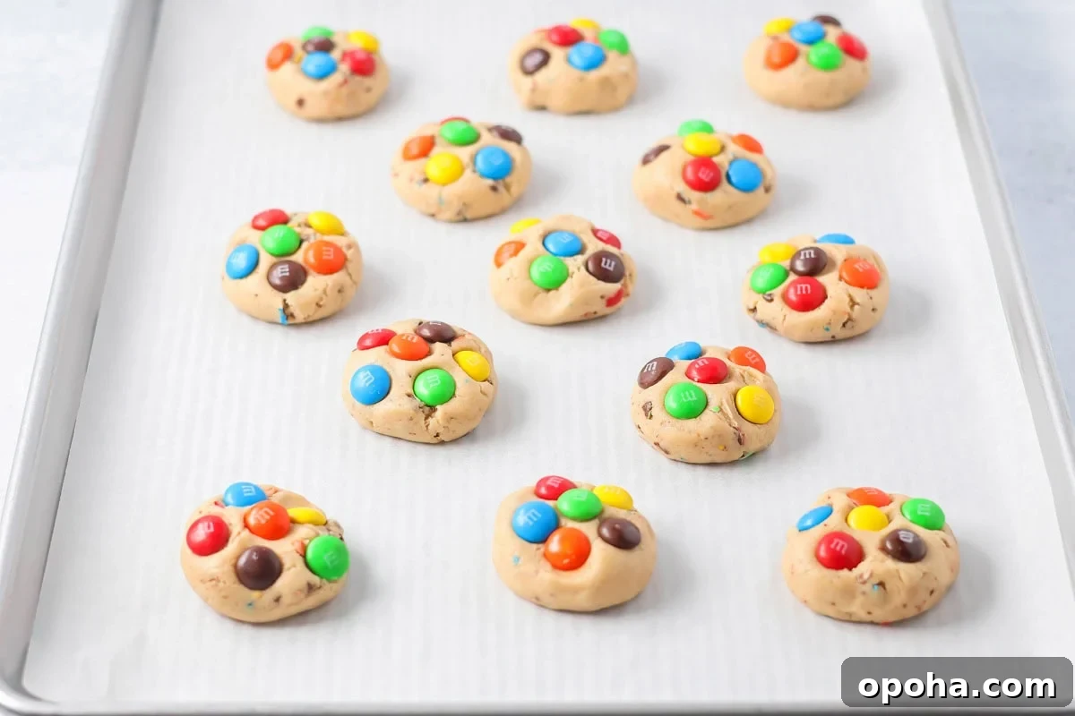 M&Ms on cookie dough on baking sheet.