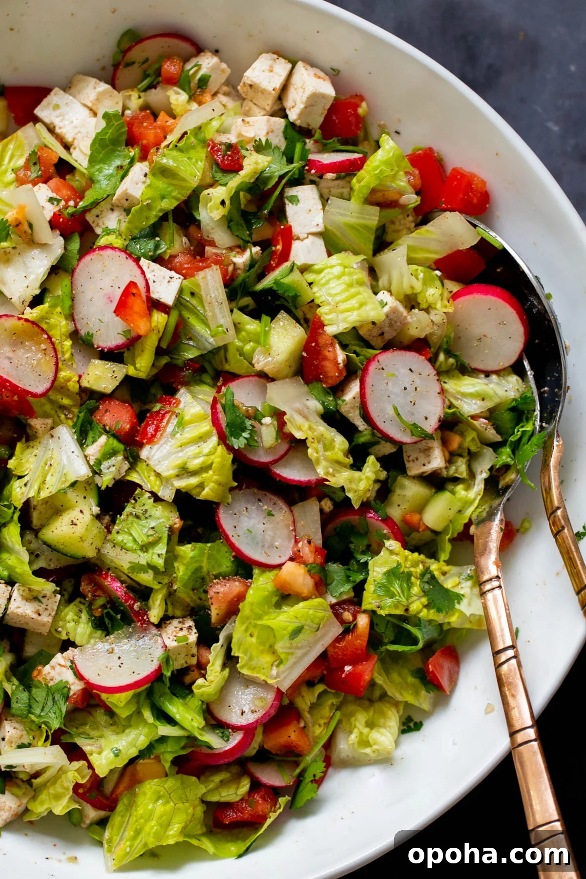 close-up of chaat masala salad in the mixing bowl with serving spoons