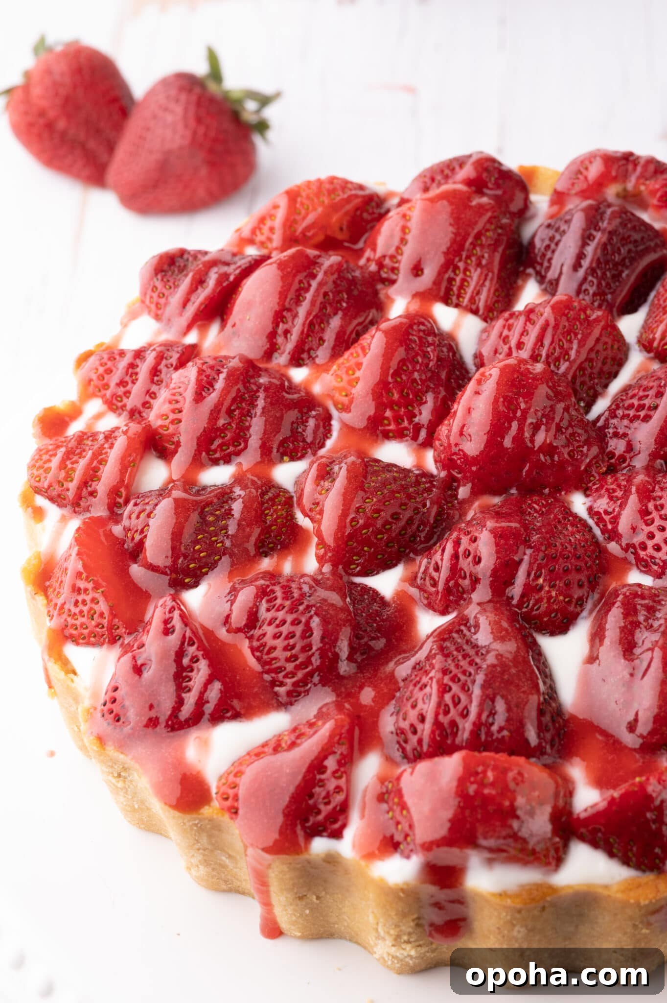 Keto strawberry cheesecake with fresh strawberries and drizzled with strawberry sauce.  
