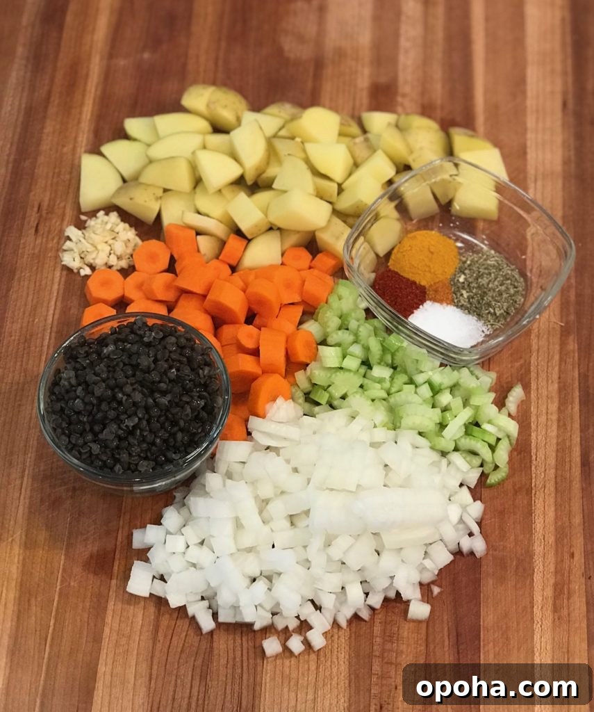 Hearty Vegan Beef-Style Stew Recipe 3 Ingredient shot for no beef stew: chunks of potatoes, carrots, celery and onions, a small glass dish of spices and another with dried black beluga lentils.
