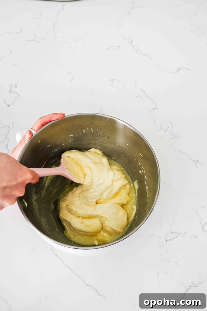 Zesty Lemon Madeleines: Classic French Tea Cakes Recipe 10 Butter is gently folded into lemon madeleine batter.