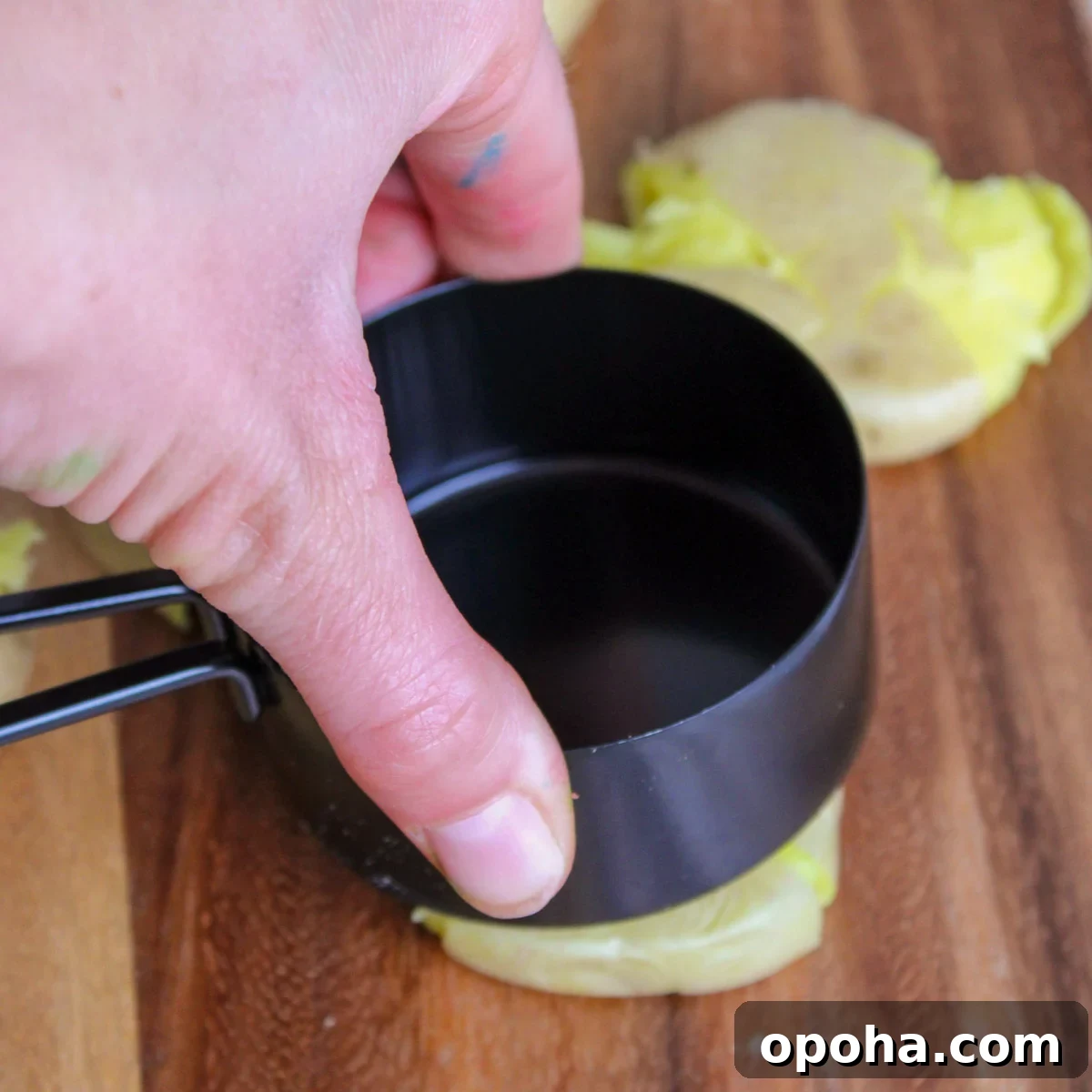 Crispy Air Fryer Smashed Potatoes Recipe 6 Smashing boiled potatoes with the bottom of a measuring cup.
