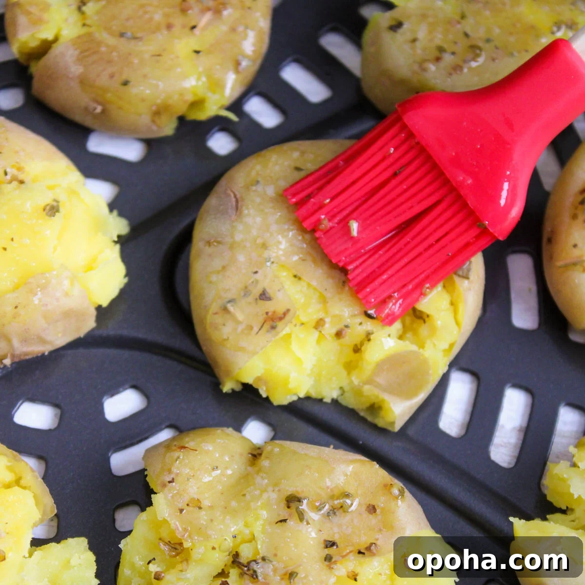 Crispy Air Fryer Smashed Potatoes Recipe 7 Seasoning potatoes in an air fryer with butter mixture.