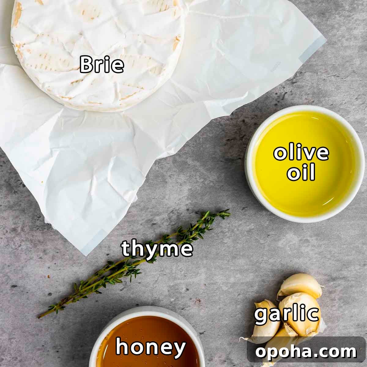Overhead shot of ingredients - brie, olive oil, thyme, honey, and garlic.