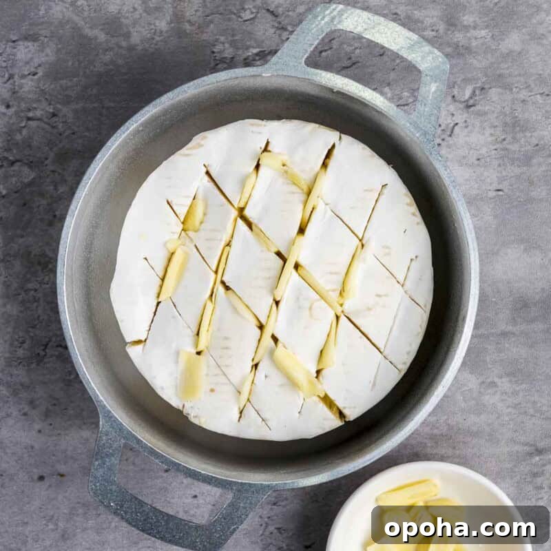 Process shot 1 - place the brie wheel in a baking dish and make small slits in the top. Insert the garlic slices into the slits.
