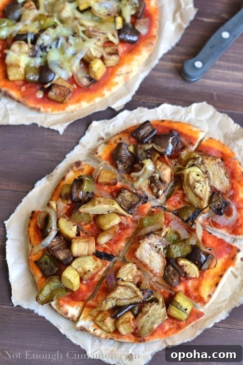 Gourmet Roasted Vegetable Pizza cut into 6 squares and served on a crinkled piece of parchment paper