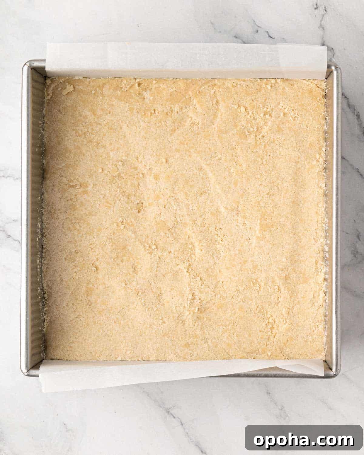 Cherry Pie Bars Recipe: Easy Homemade Cherry Dessert Bars 11 Shortbread cookie mixture pressed into the bottom of a baking dish lined with parchment.