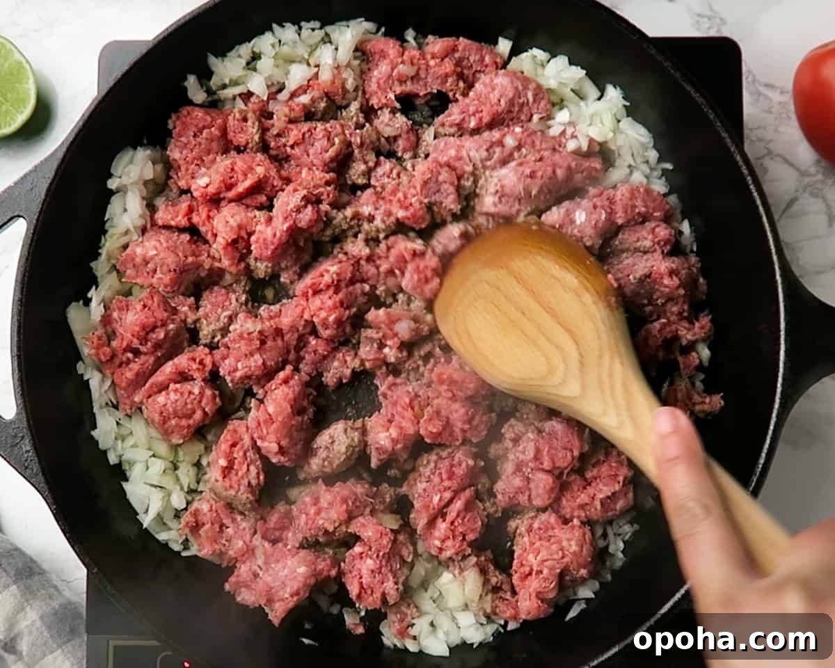 Taco Meat Recipe: Skillet, Instant Pot, or Crock Pot Options 3 lean ground beef and onions being cooked in cast iron skillet