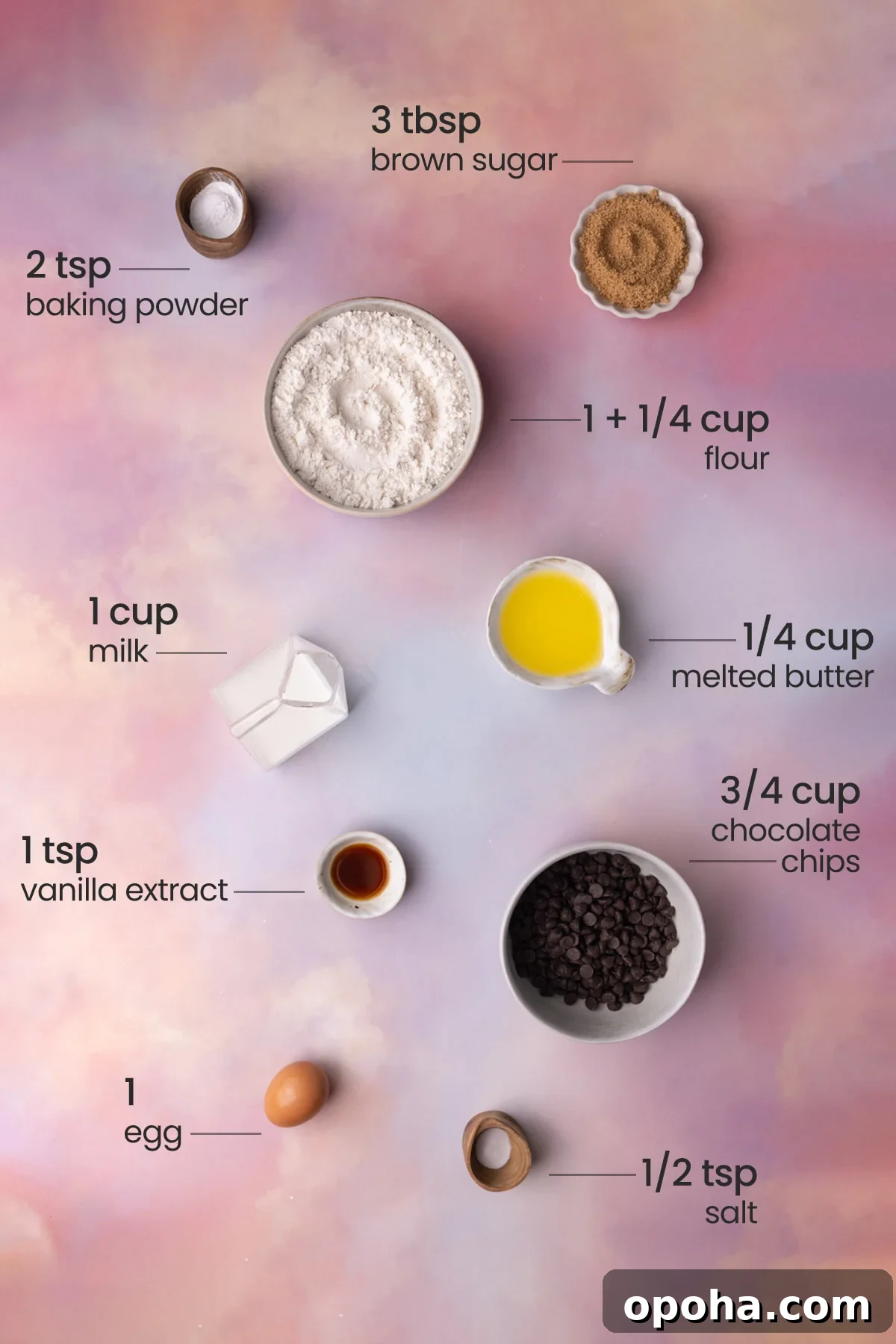 Overhead view of all ingredients needed for chocolate chip waffles - brown sugar, baking powder, flour, milk, melted butter, vanilla extract, chocolate chips, egg, and salt.
