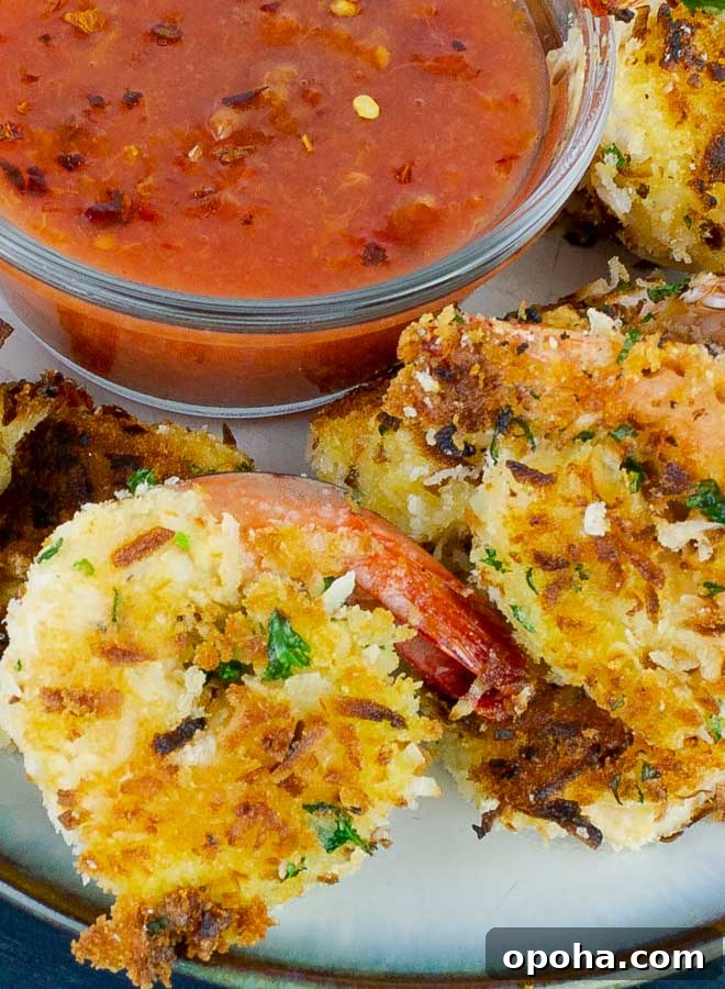 two Coconut Shrimp with a bowl of Peach Sweet and Spicy Chili Sauce