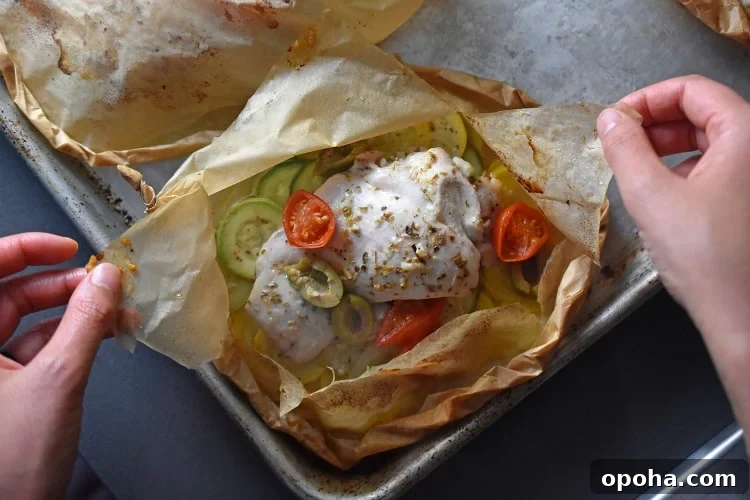 Opening up a Lemon Garlic Chicken Parchment Packet after taking it out of the oven.