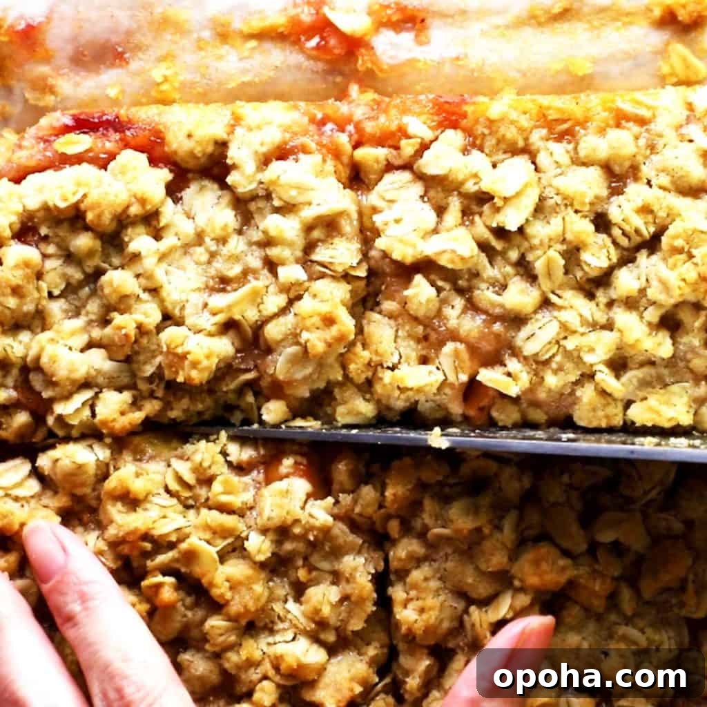 Raspberry and peach oatmeal bars being cut into squares