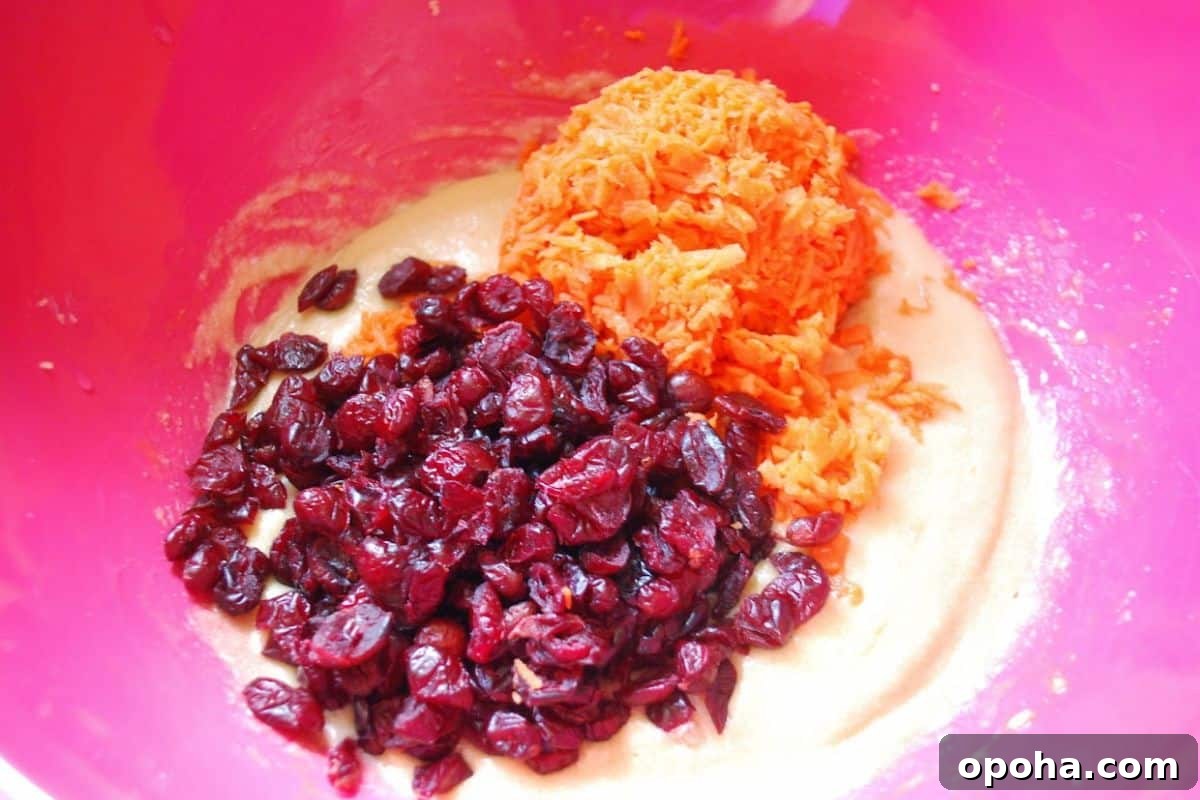 Carrot Cake Cookies Recipe — Moist Spiced Cookies with Cream Cheese Frosting 3 craisins and carrots in a bowl