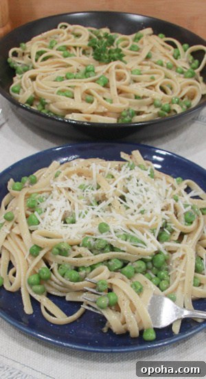 Freshly grated Parmesan cheese over a plate of fettuccine in a buttery pepper sauce.