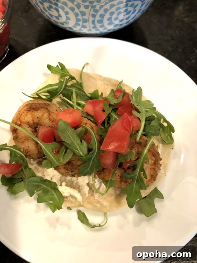 WeightWatchers-Friendly Spiced Shrimp Tacos with Lime Slaw 5 Spice-Rubbed Soft Shrimp Taco topped with tomatoes and arugula on plate