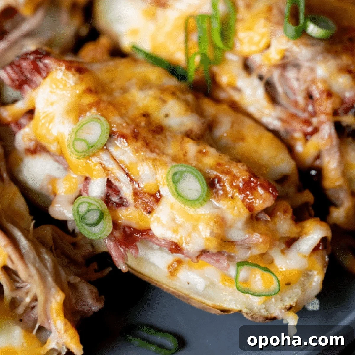 A game day appetizer of smoked potato skins topped with cheese, bacon, and chives.