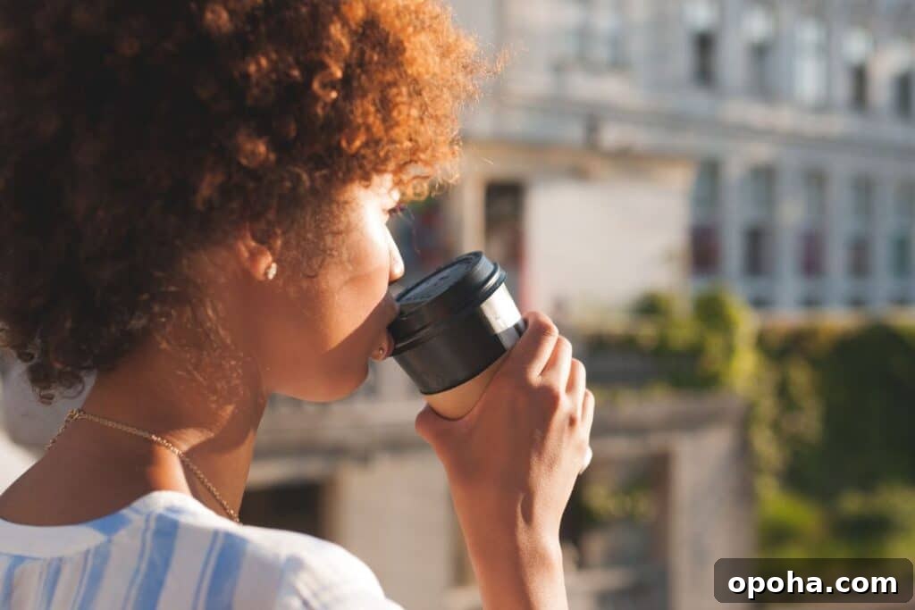 A woman taking a sip of a coffee.