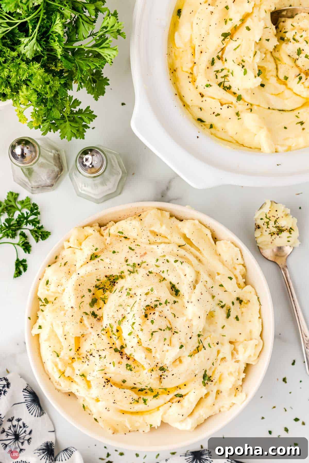 Decadent Million Dollar Mashed Potatoes Recipe 11 two bowls of million dollar mashed potatoes next to salt and pepper shakers