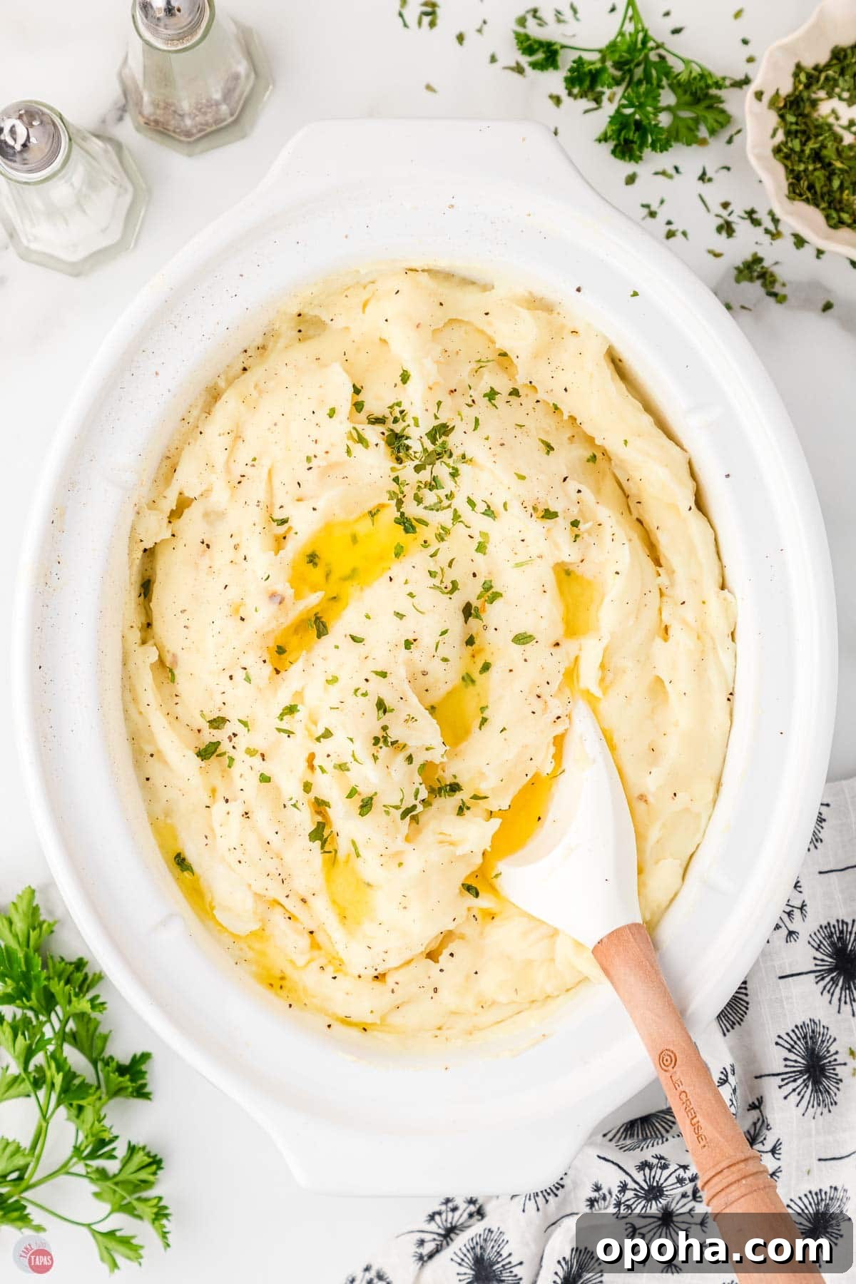 Decadent Million Dollar Mashed Potatoes Recipe 8 white slow cooker full of mashed potatoes with a spatula in it
