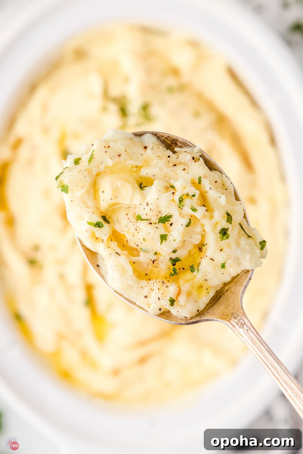 Decadent Million Dollar Mashed Potatoes Recipe 9 close up of silver spoon with a bite of mashed potatoes and butter in it