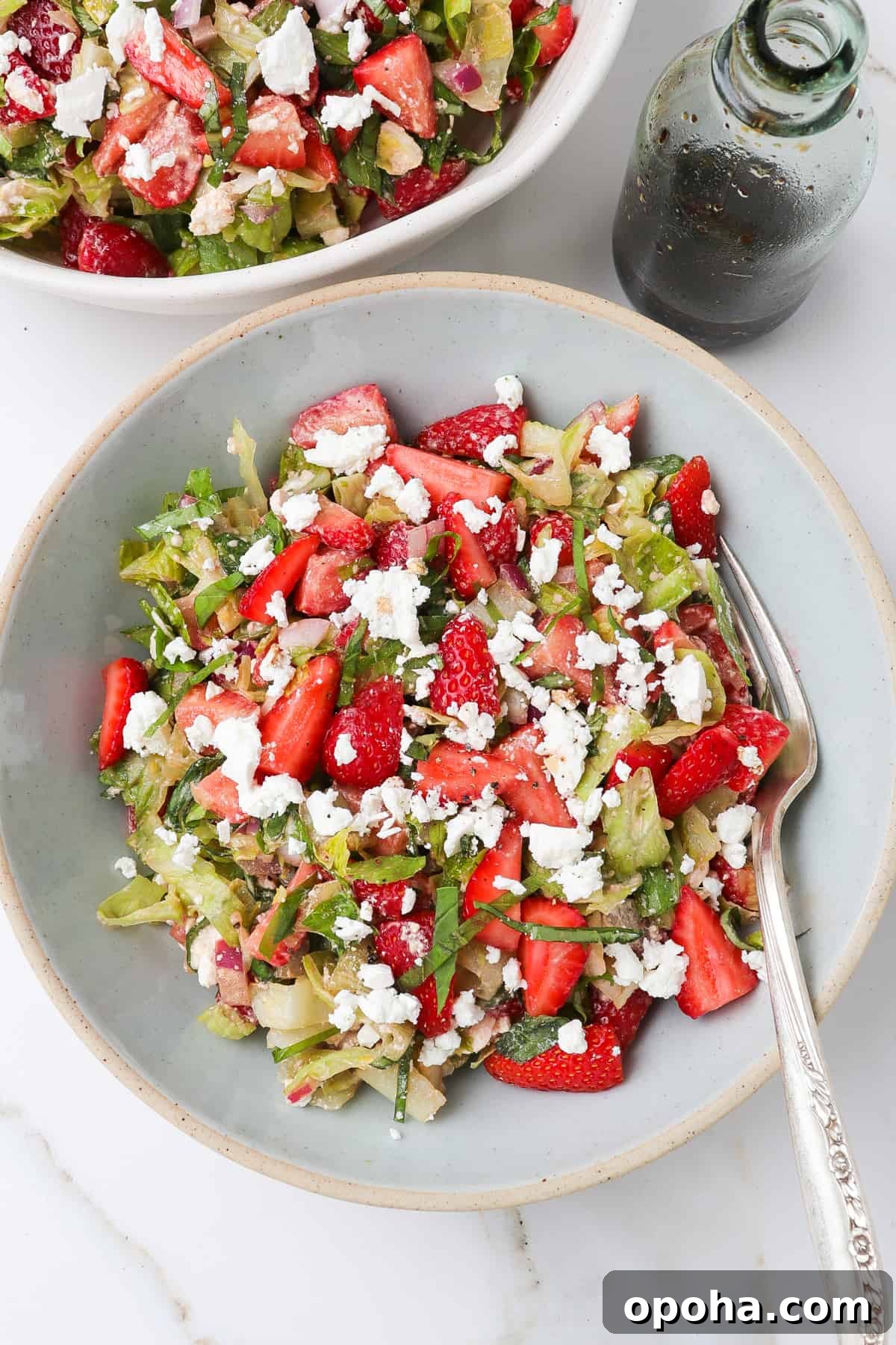 Strawberry and Goat Cheese Salad with Balsamic Glaze 7 Strawberry goat cheese salad in a blue bowl with balsamic dressing on the side.