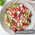 Strawberry salad in a blue bowl with a fork at the top.