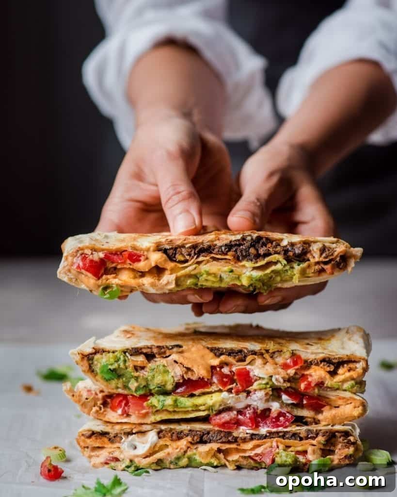 holding vegan crunchwrap supreme