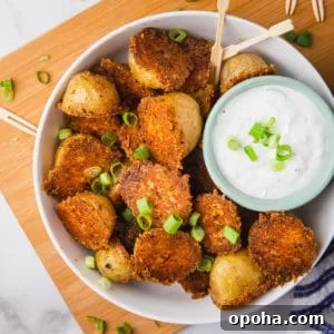 parmesan crusted potatoes in a bowl with a creamy white dip and green onions