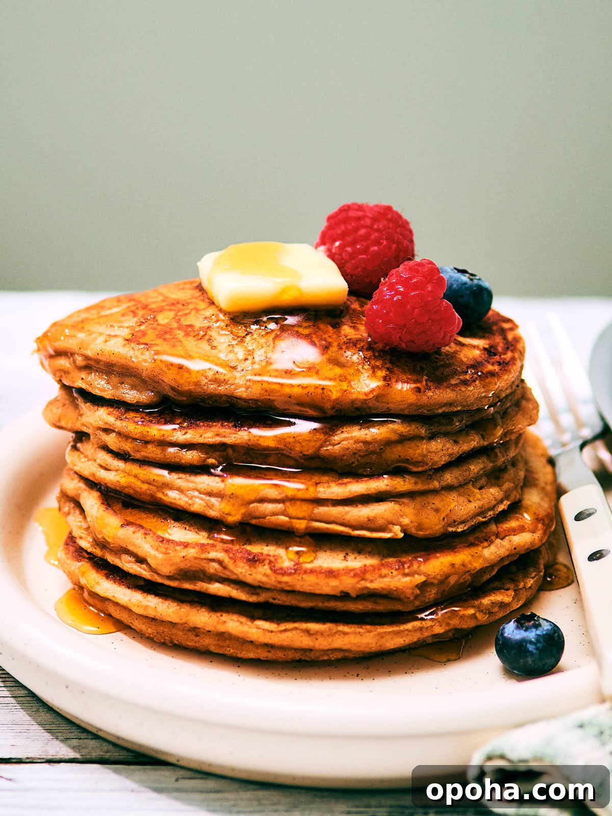 High-Protein Cottage Cheese Pancakes for Muscle Gain and Weight Loss 2 A stack of High Protein Cottage Cheese pancakes on a plate with berries.