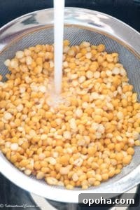 A strainer full of yellow split peas being rinsed