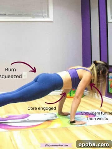 woman in blue pants and purple sports bra in a high plank position