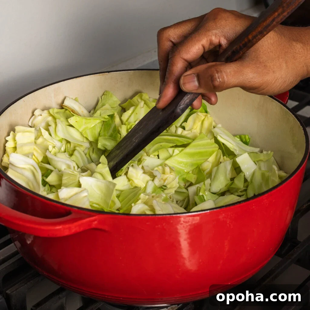 Southern-Style Fried Cabbage Recipe for Bold Flavor 7 stirring chopped cabbage in dutch oven