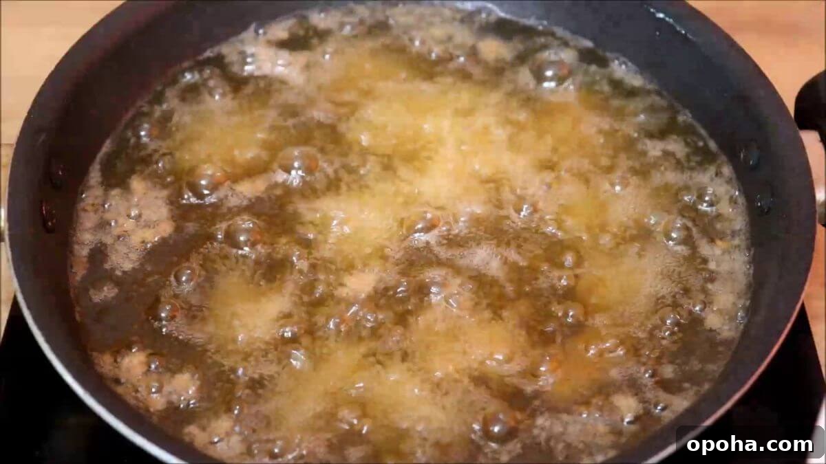 Crispy Homemade Popcorn Chicken Recipe for Snack or Dinner 6 frying popcorn chicken in hot oil.