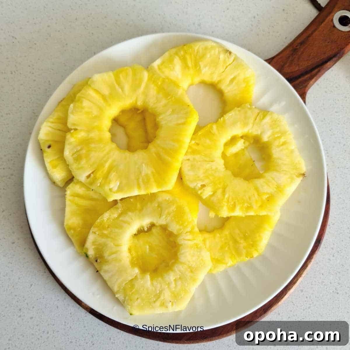 Air Fryer Cinnamon Pineapple Recipe — Grilled Flavor in Minutes 5 pineapple rings placed on a white plate