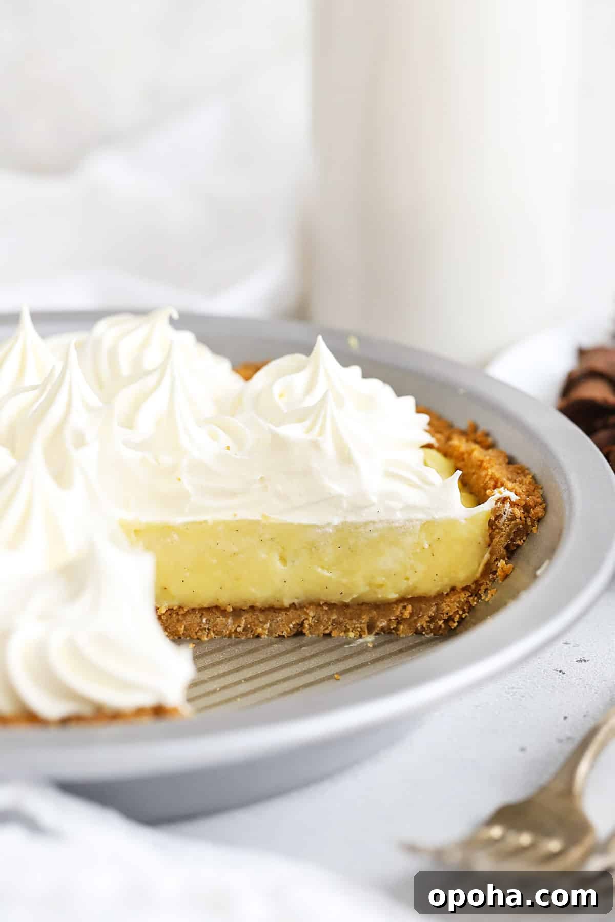 Gluten-Free Banana Cream Pie Recipe — Light, Silky & Delicious 9 Front view of a gluten-free banana cream pie with a few slices removed