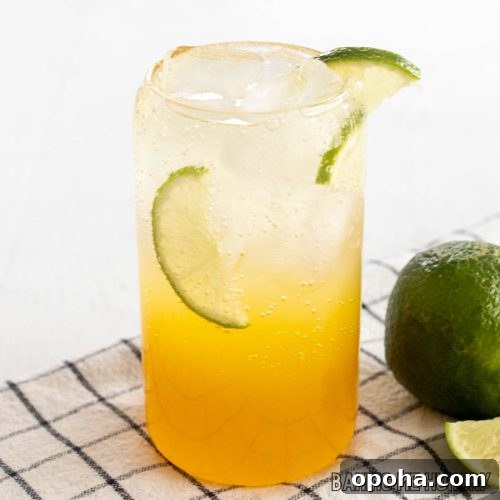 passion fruit mocktail recipe in a tall glass with lime slices