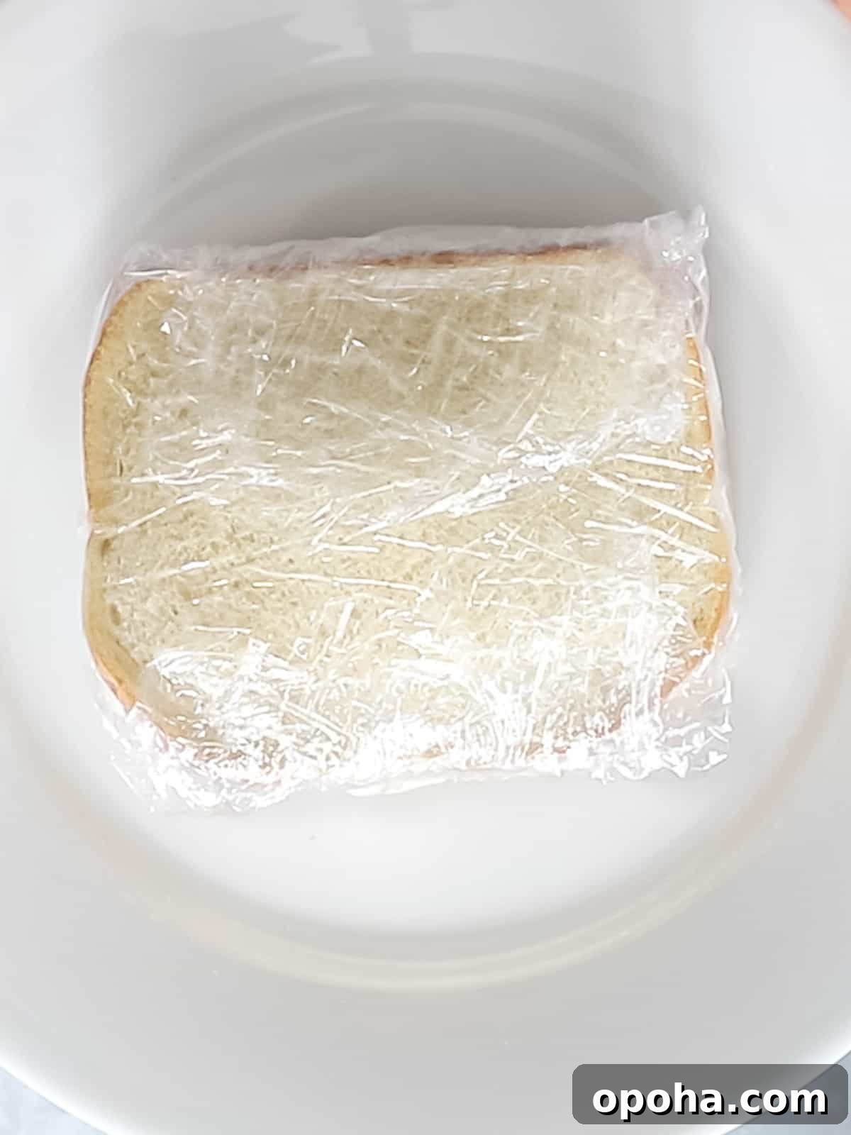 Japanese Fruit Sandwich (Strawberry Sando): How to Make フルーツサンド 11 Japanese fruit sandwich wrapped in plastic wrap on a white plate.